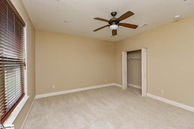 unfurnished bedroom with light colored carpet, ceiling fan, visible vents, and baseboards