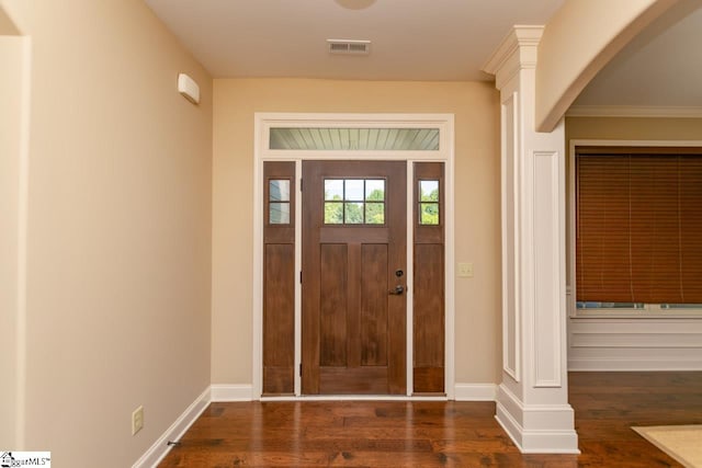 foyer featuring dark wood-style floors, baseboards, visible vents, and arched walkways