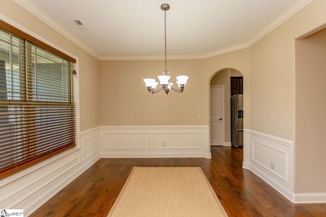 unfurnished dining area with dark hardwood / wood-style floors, a notable chandelier, and ornamental molding