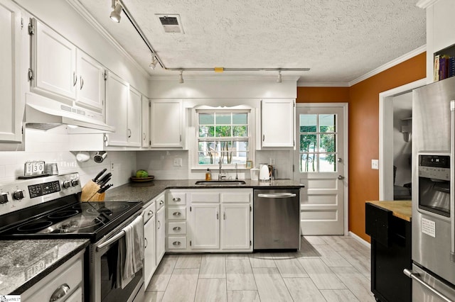 kitchen featuring a textured ceiling, stainless steel appliances, sink, rail lighting, and white cabinets