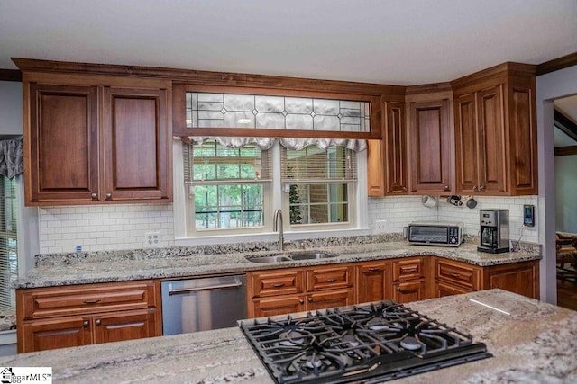 kitchen featuring dishwasher, gas cooktop, sink, and backsplash