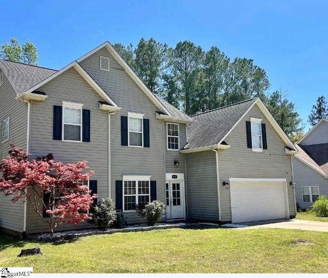 view of front of house with a front yard and a garage