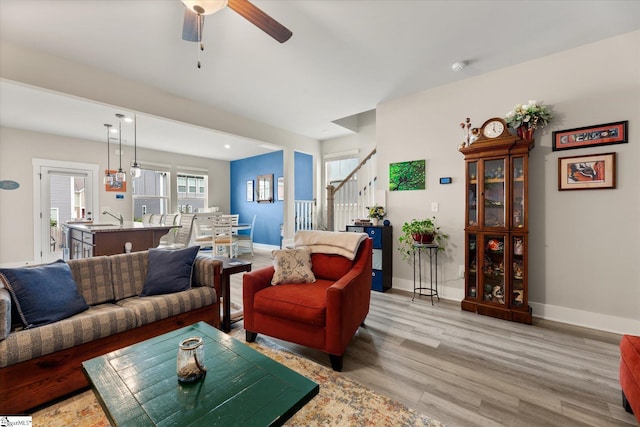 127 Addington Ln, Simpsonville, SC 29681 - living room featuring light wood-style floors, baseboards, stairway, and a ceiling fan