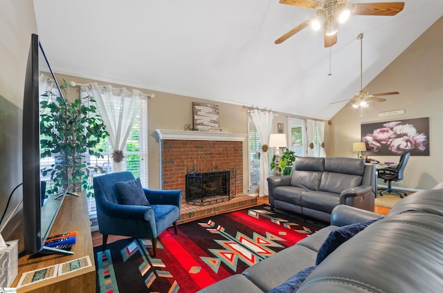 living room featuring a wealth of natural light, ceiling fan, wood-type flooring, and a brick fireplace