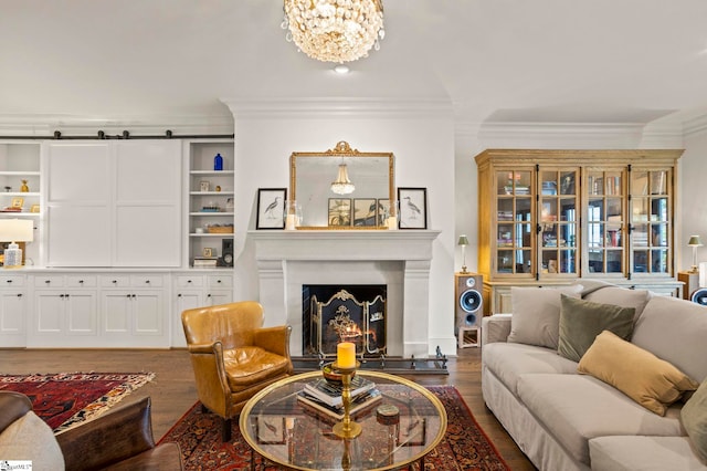 living room with crown molding, a chandelier, hardwood / wood-style floors, and a barn door