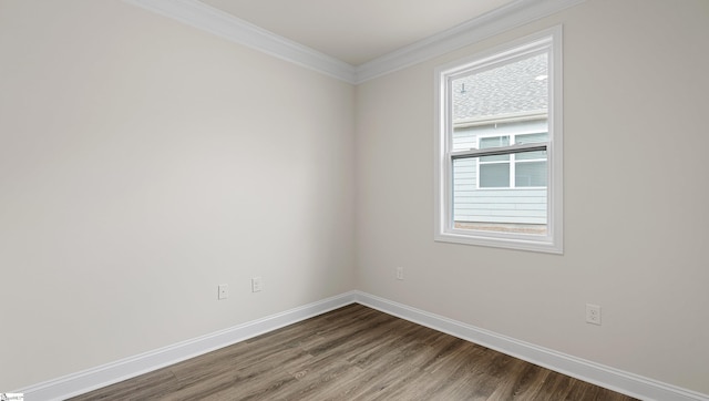 empty room with wood-type flooring and ornamental molding