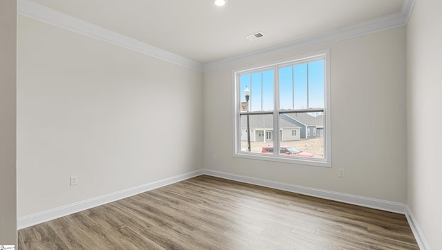 spare room featuring hardwood / wood-style floors and crown molding