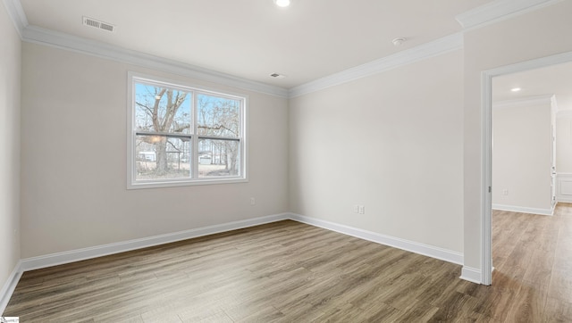 empty room with wood-type flooring and crown molding