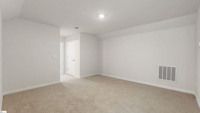 unfurnished room with vaulted ceiling and light carpet