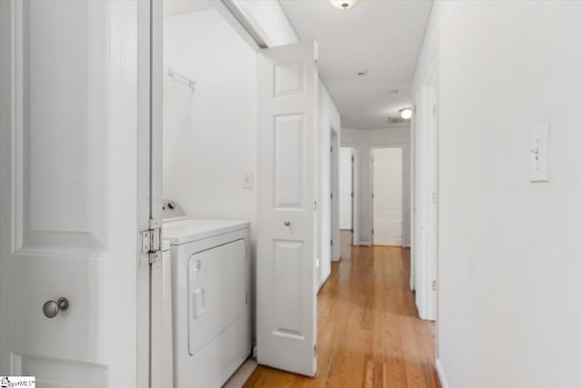 laundry area featuring washer and clothes dryer and light hardwood / wood-style floors