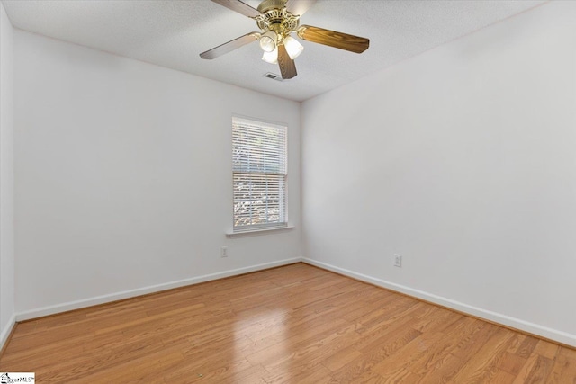 empty room featuring a textured ceiling, light hardwood / wood-style floors, and ceiling fan