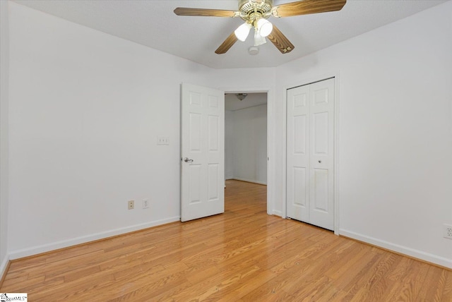 unfurnished bedroom featuring ceiling fan, a closet, and light wood-type flooring