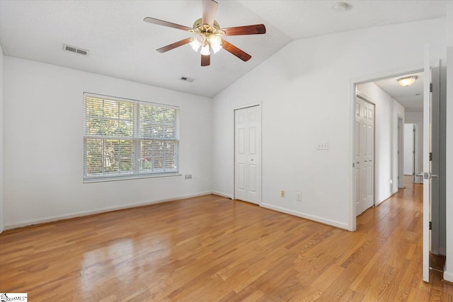 unfurnished bedroom featuring light hardwood / wood-style flooring, ceiling fan, and lofted ceiling