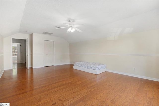 bonus room with ceiling fan, dark wood-type flooring, and lofted ceiling