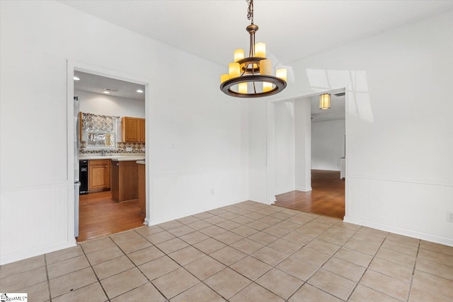 unfurnished room with light tile patterned floors and an inviting chandelier