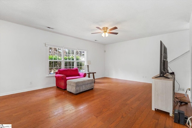 sitting room featuring wood-type flooring, a textured ceiling, and ceiling fan