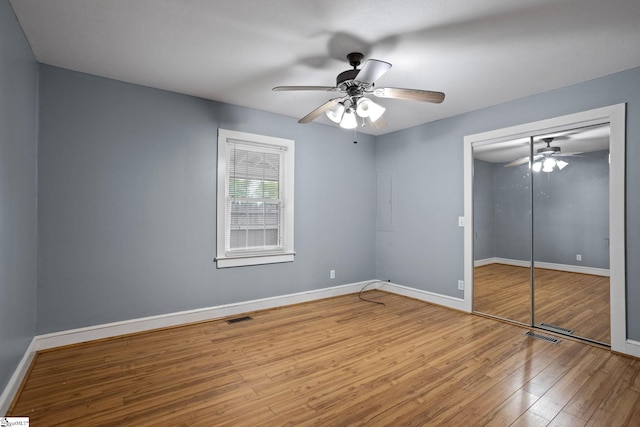 unfurnished bedroom with hardwood / wood-style floors, ceiling fan, and a closet