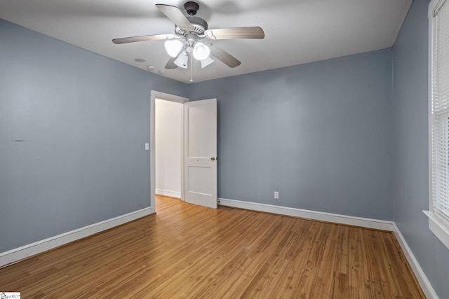 empty room with ceiling fan and light hardwood / wood-style flooring