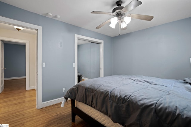 bedroom with hardwood / wood-style floors, ceiling fan, and a closet