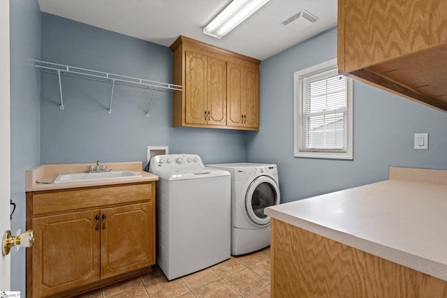 laundry area with light tile patterned flooring, sink, washing machine and clothes dryer, and cabinets