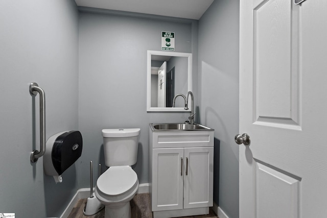 bathroom with vanity, toilet, and hardwood / wood-style flooring