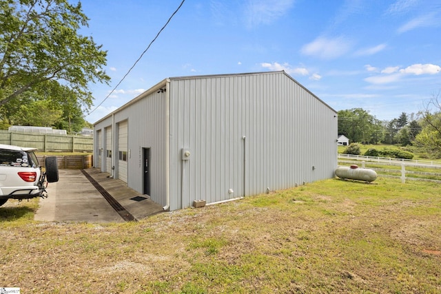 view of outdoor structure featuring a lawn and a garage