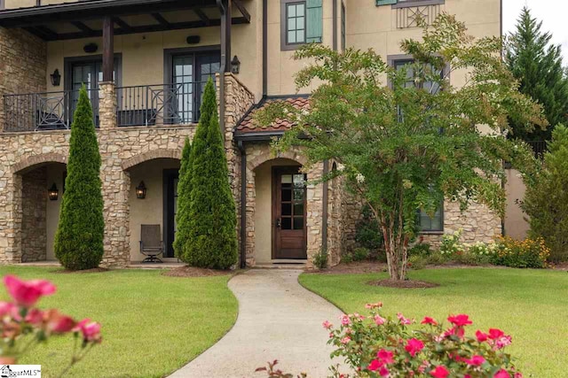 view of front facade featuring a balcony and a front lawn