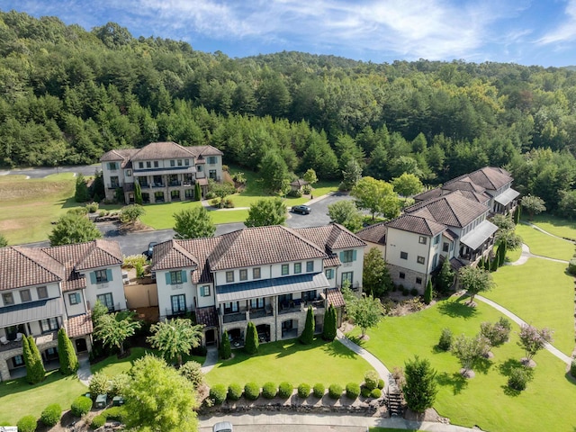 drone / aerial view featuring a forest view and a residential view