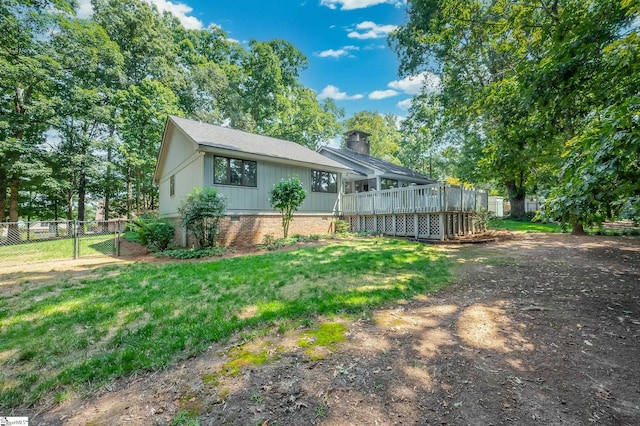 view of side of property with a yard and a wooden deck