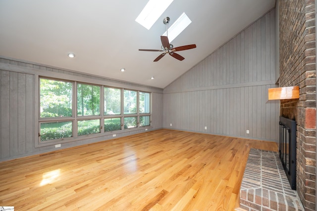 unfurnished living room featuring a wealth of natural light, hardwood / wood-style floors, a skylight, and a fireplace