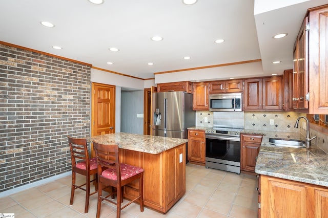 kitchen featuring a center island, light stone countertops, stainless steel appliances, and sink