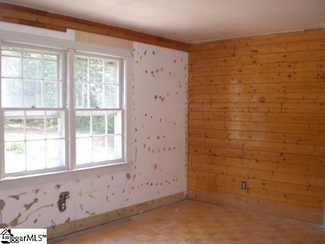 spare room with wooden walls and parquet flooring