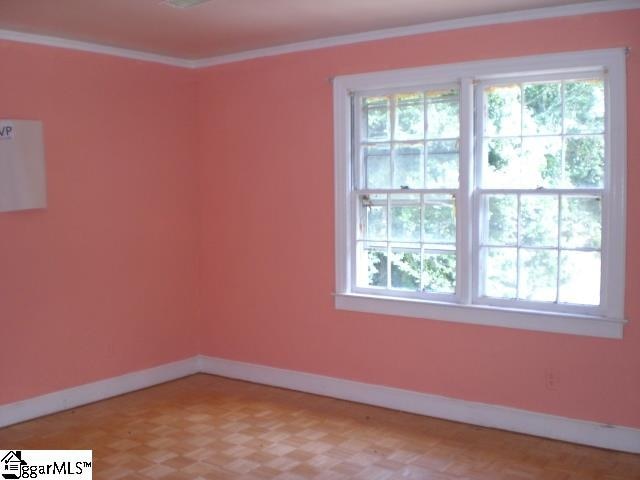 unfurnished room with crown molding and parquet flooring