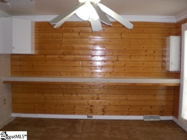 interior space with ceiling fan, crown molding, and carpet floors