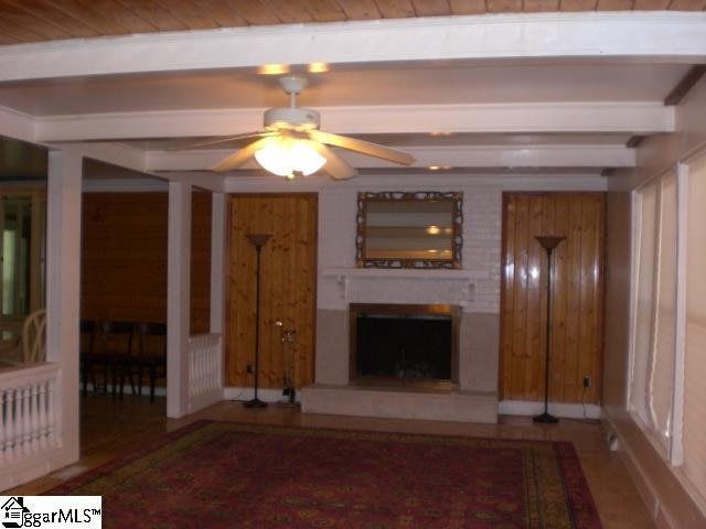 unfurnished living room with ceiling fan and beam ceiling