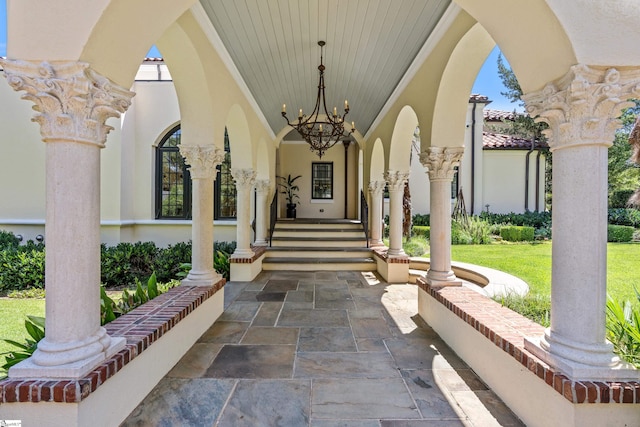 view of exterior entry with a yard and a porch