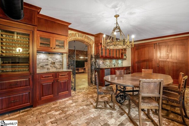 dining area with crown molding and an inviting chandelier