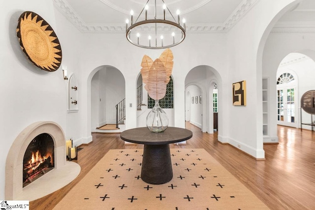 foyer entrance with an inviting chandelier, crown molding, and light hardwood / wood-style flooring