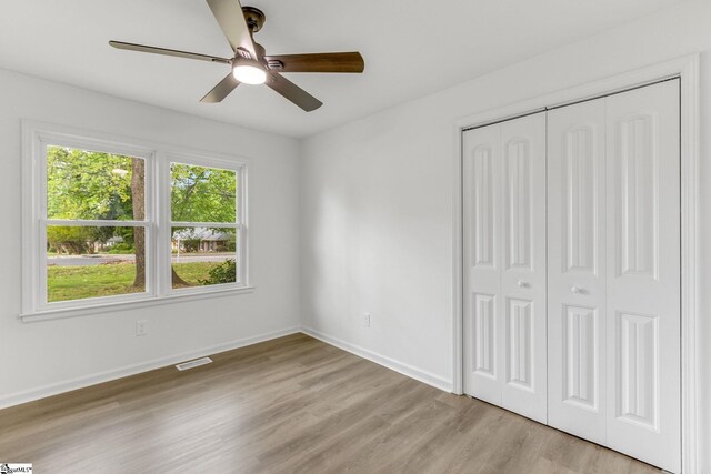 unfurnished bedroom with ceiling fan, a closet, and light hardwood / wood-style floors