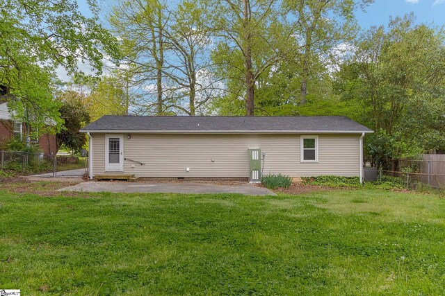 rear view of property featuring a lawn and a patio area