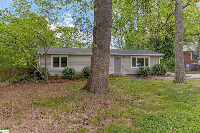 ranch-style house featuring a front yard and fence