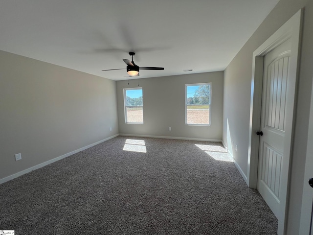 carpeted spare room with ceiling fan