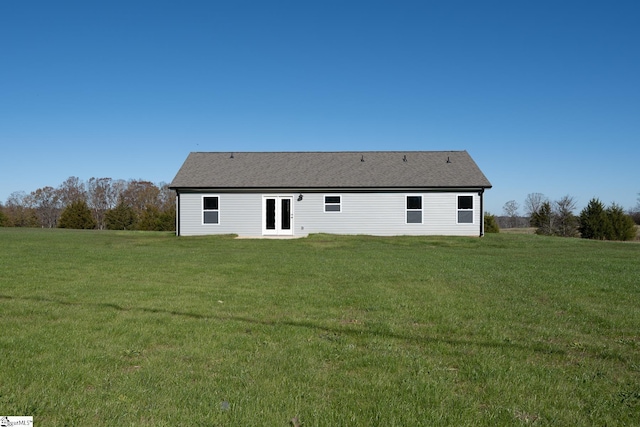 rear view of property with a lawn