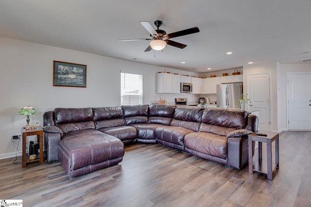 living room featuring light wood-type flooring and ceiling fan