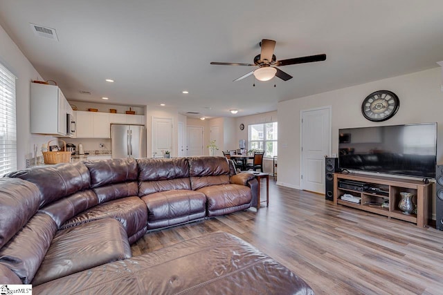 living room featuring ceiling fan and light hardwood / wood-style floors