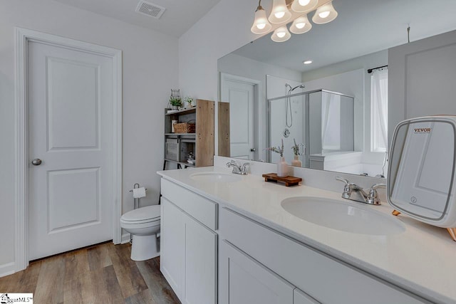 bathroom with vanity, toilet, wood-type flooring, and walk in shower