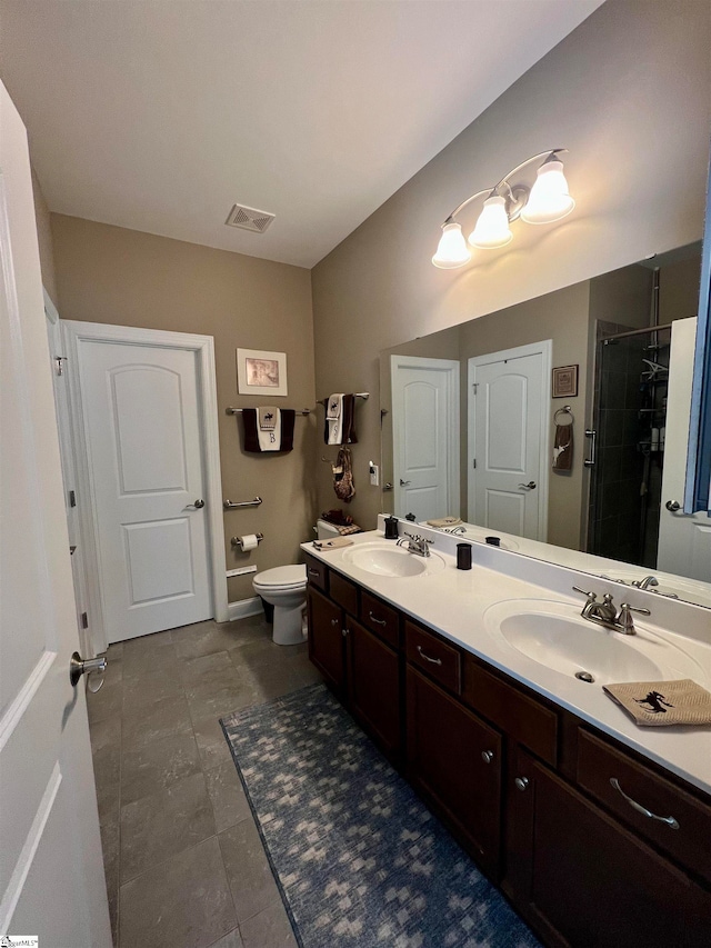 bathroom with tile patterned flooring, vanity, toilet, and a shower with shower door