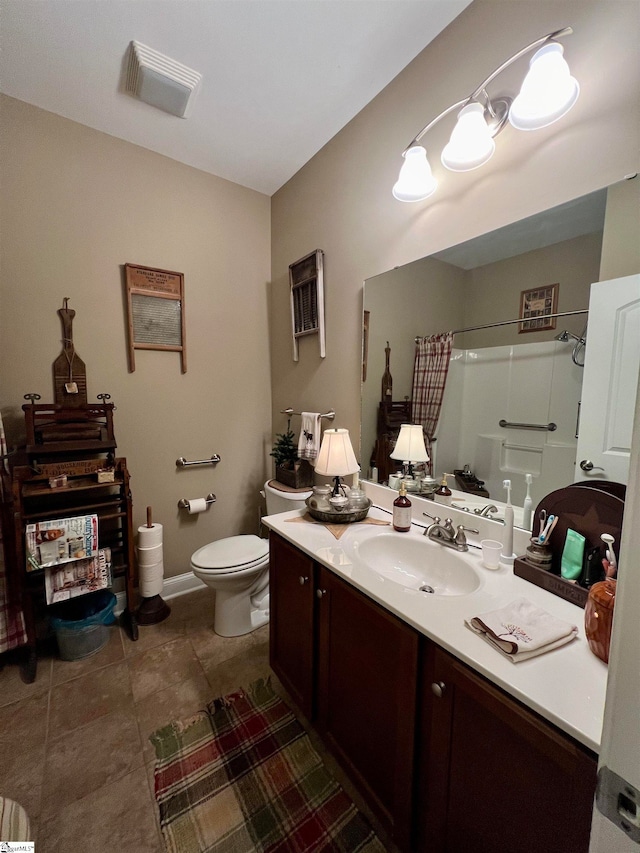 bathroom featuring vanity, toilet, and walk in shower