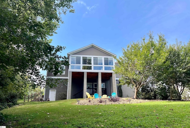 rear view of property with a sunroom and a yard