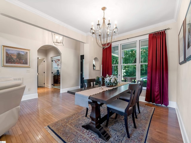 dining space featuring dark hardwood / wood-style flooring, a notable chandelier, and ornamental molding